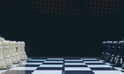 A chessboard with white and black pieces set for a game. Pieces are aligned, creating a tense, strategic atmosphere against a dark background.