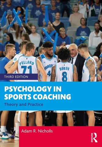 A basketball coach passionately talks to his team during a game, with cheering fans holding blue banners in the background. Cover of "Psychology in Sports Coaching" by Adam R. Nicholls.
