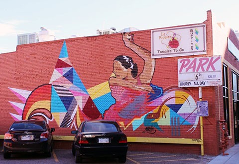 Painted mural on 2033 Lawrence Street. Image Source: Auraria Library Digital Collections Colorful mural of woman dancing painted onto a brick wall of an older Denver establishment.
