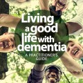 A group of people smiling and holding hands together, surrounded by greenery, showcasing unity and support in a caregiving context.